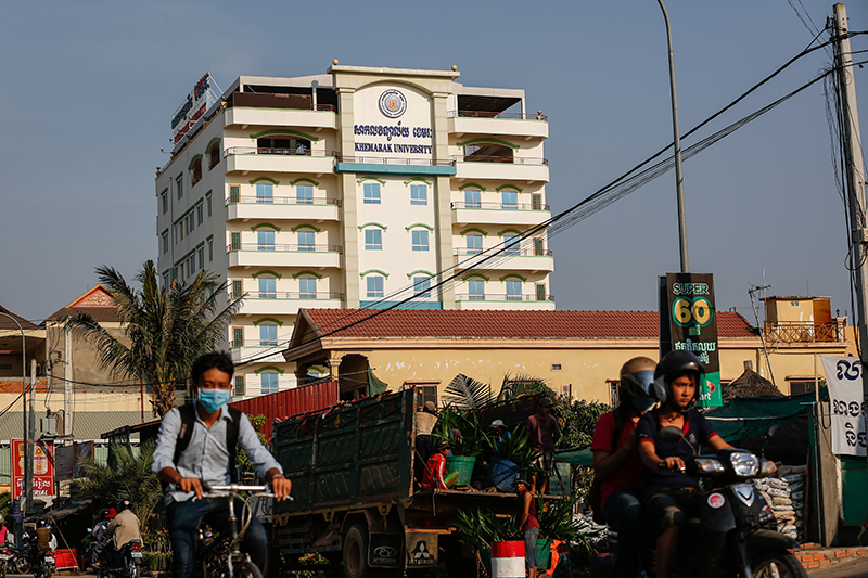 Motorists drive past Khemarak University in Phnom Penh on Monday. (Siv Channa/The Cambodia Daily)