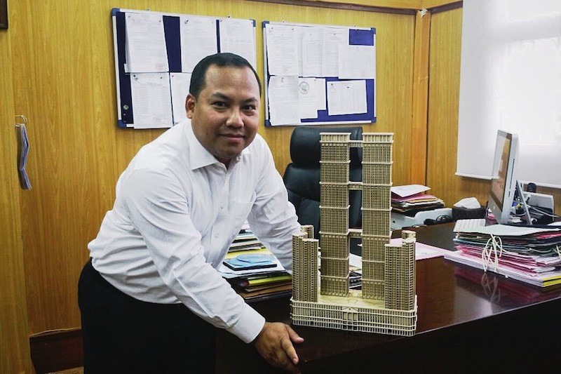 Phnom Penh City Hall spokesman Long Dimanche poses with a model of the Thai Boon Roong Twin Trade Center in a photograph posted to his Facebook page.