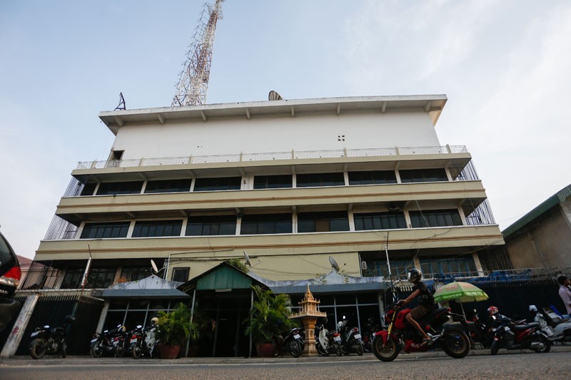 A man on a motorbike drives past TV9's headquarters in Phnom Penh on Thursday. (Siv Channa/The Cambodia Daily)