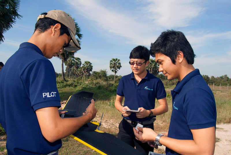 SMWaypoint staff members examine one of the company's drones. (SMWaypoint)