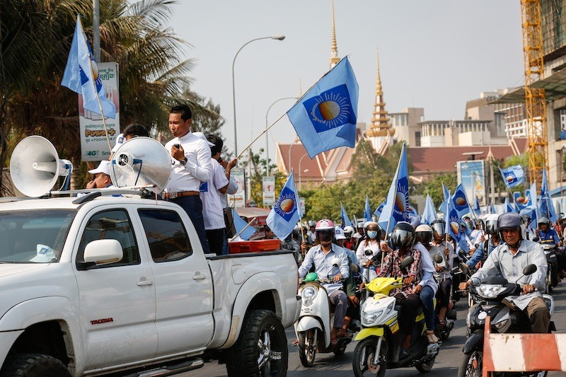 Dressed in CNRP hats and shirts, a group of students parades through Phnom Penh on Tuesday protesting against deputy opposition leader Kem Sokha's refusal to respond to accusations that he had extramarital affairs. (Siv Channa/The Cambodia Daily)