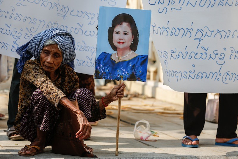 An evictee from Phnom Penh's Borei Keila neighborhood holds up a picture of Prime Minister Hun Sen's wife, Bun Rany, outside City Hall on Wednesday. (Siv Channa/The Cambodia Daily)