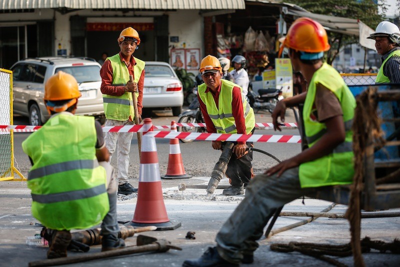 A laborer uses a jackhammer to drill into a street in Phnom Penh on Wednesday to install electrical cables that will connect the city's traffic lights to a single command center. (Siv Channa/The Cambodia Daily)