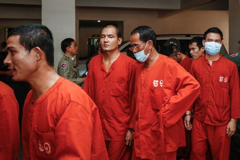Ouk Sithorn, second from right, leaves the Phnom Penh Municipal Court yesterday. (Siv Channa/The Cambodia Daily)