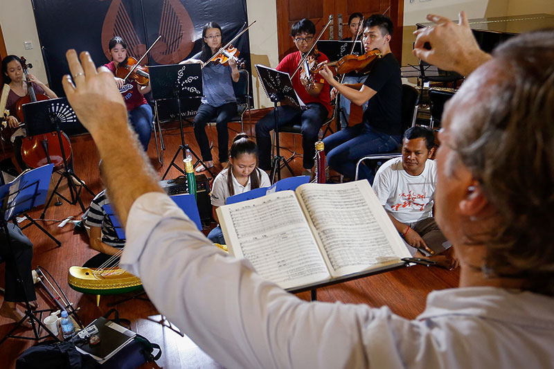 Aaron Carpene conducts Cambodian musicians and violinists from the Yong Siew Toh Conservatory of Music in Phnom Penh on Tuesday. (Siv Channa/The Cambodia Daily)