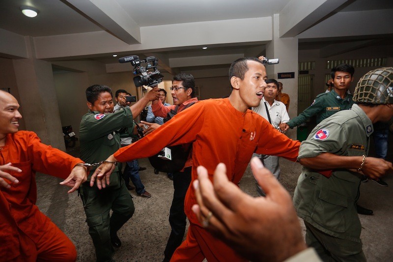 Former monks Chea Vanda, left, and Dav Tep are escorted from the Phnom Penh Municipal Court, where they stood trial yesterday on charges of drug possession, using fake documents and making death threats. (Siv Channa/The Cambodia Daily)