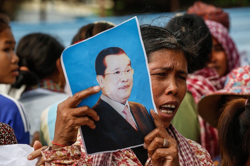 A protester holds up a picture of Prime Minister Hun Sen outside the National Assembly in Phnom Penh on Tuesday. (Siv Channa/The Cambodia Daily)