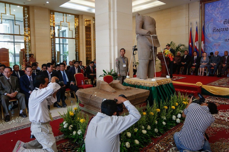 Photographers take photos of the Torso of Rama during a handover ceremony at the Council of Ministers building in Phnom Penh yesterday. (Siv Channa/The Cambodia Daily) 