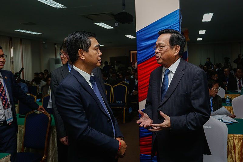 Labor Minister Ith Sam Heng, right, speaks with International Labor Organization coordinator Thun Sophorn at the National Assembly in Phnom Penh on Wednesday. (Siv Channa/The Cambodia Daily)