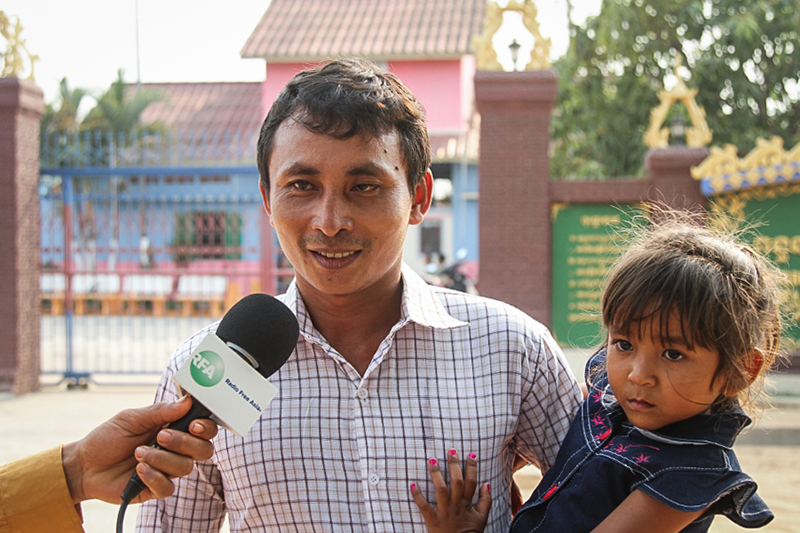Ven Vorn holds his 4-year-old daughter Vorn Sovann Sera as he speaks with reporters outside the Koh Kong Provincial Prison Thursday. (Den Seymar) 