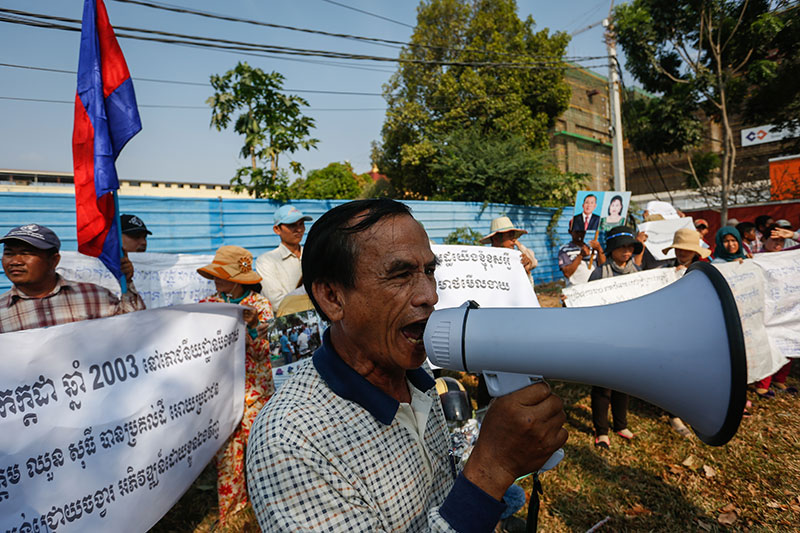 A community leader speaks through a megaphone near the National Assembly during a protest against the proposed privatization of 280 hectares of land in Phnom Penh's Chroy Changva district. (Siv Channa/The Cambodia Daily)