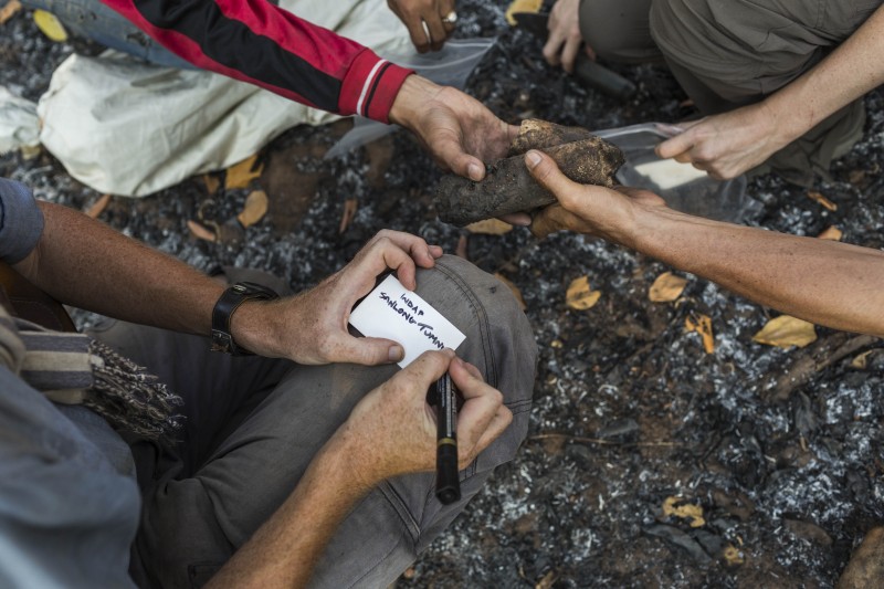 A team of archaeologists record data of an iron scoria sample at the temple complex. (Enric Catala)