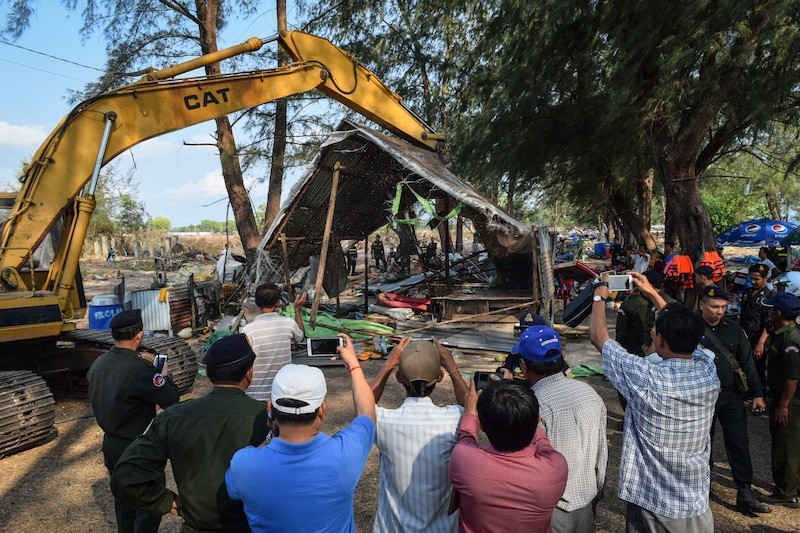 Authorities use an excavator to demolish a stall on O'Chheuteal beach in Sihanoukville in April . (Peter Ford/The Cambodia Daily)