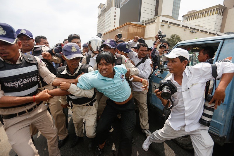 Government security guards drag protesting union official Suot Chet away from the National Assembly in Phnom Penh on Monday. (Siv Channa/The Cambodia Daily)