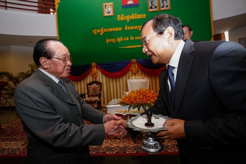 Outgoing Foreign Affairs Minister Hor Namhong, left, shakes hands with his successor, Prak Sokhon, at a handover ceremony in Phnom Penh on Tuesday. (Siv Channa/The Cambodia Daily)