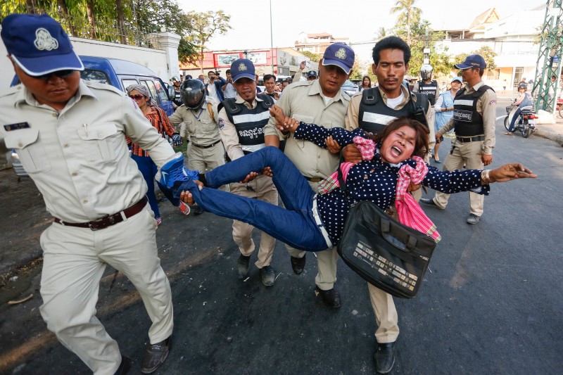 A woman is carried away from the Anti-Corruption Unit's headquarters in Phnom Penh on Wednesday while protesting the questioning of rights workers over a sex scandal involving deputy opposition leader Kem Sokha. (Siv Channa/The Cambodia Daily)