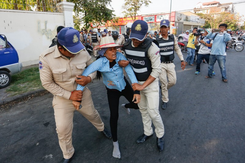 A woman is carried away from the Anti-Corruption Unit’s offices in Phnom Penh on Wednesday while protesting the questioning of four rights workers about claims that they persuaded deputy opposition leader Kem Sokha’s alleged mistress to deny their affair. (Siv Channa/The Cambodia Daily)