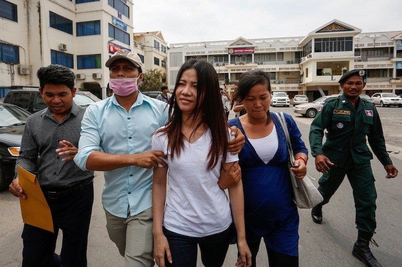 Khem Chandaraty, center, leaves the Interior Ministry in Phnom Penh after being questioned by police last month. (Siv Channa/The Cambodia Daily)
