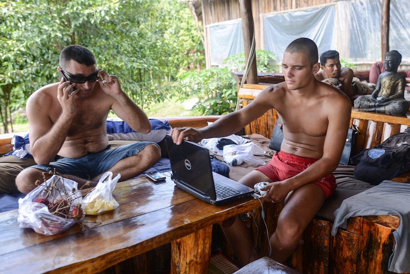 Vladimir Batalin, left, speaks on the telephone during an outing to Koh Rong island off the coast of Sihanoukville in October 2013. (Ben Woods/The Cambodia Daily)