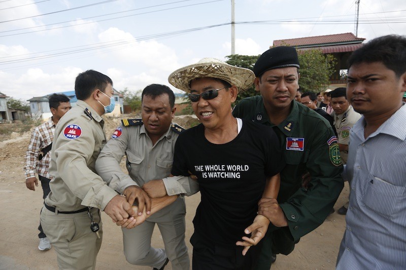 Thav Kimsan, deputy director of advocacy for rights group Licadho, is apprehended Monday morning by police in Phnom Penh's Dangkao district. (Siv Channa/The Cambodia Daily)