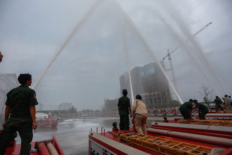 Police test newly purchased fire trucks on Tuesday during a handover ceremony on Phnom Penh's Koh Pich island. (Siv Channa/The Cambodia Daily)