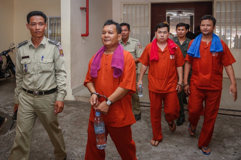 The three defendants on trial for the beating of two opposition lawmakers last year arrive at the Phnom Penh Municipal Court on May 10. (Siv Channa/The Cambodia Daily)