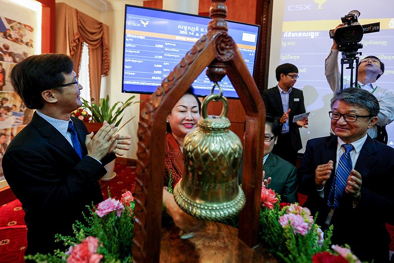 Lim Chhiv Ho, chairwoman of the Phnom Penh Special Economic Zone, rings in the company's initial public offering at the Cambodia Securities Exchange on Monday. (Pring Samrang/Reuters)