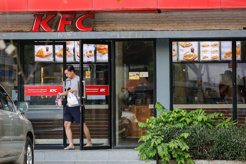 A customer leaves KFC with a takeaway order.