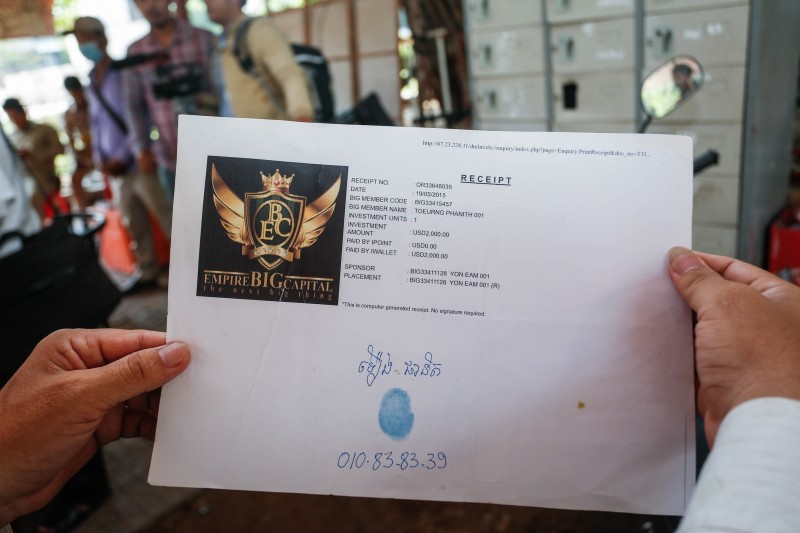 A man shows a receipt of his investment in Empire Big Capital in Phnom Penh on Thursday before delivering a petition with about 20 others calling for Prime Minister Hun Sen's help in getting their money back. (Siv Channa/The Cambodia Daily)