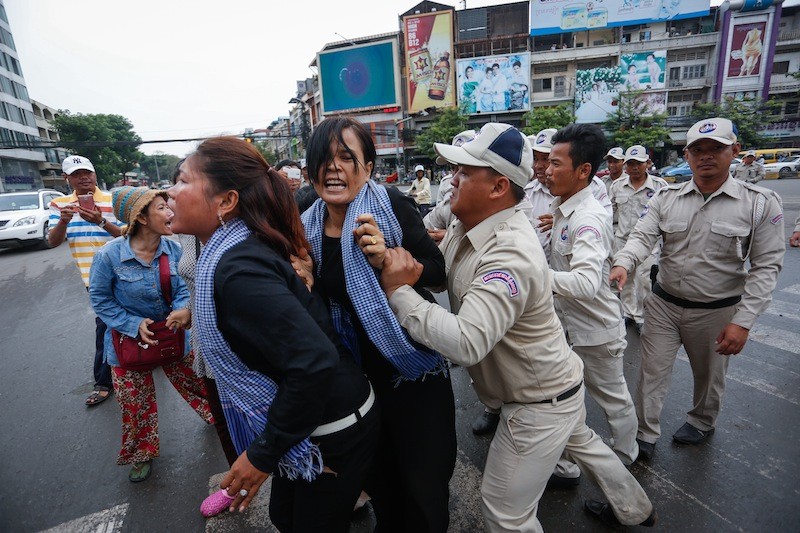 State security guards push protesters toward a police truck on Monday in Phnom Penh after they attempted to gather for the second 'Black Monday' demonstration. (Siv Channa/The Cambodia Daily)