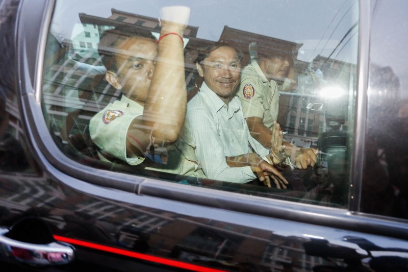 UN, Adhoc Staff Charged Over Sex Scandal 1 Ny Sokha, Adhoc's head of monitoring, sits in a car with Anti-Corruption Unit officials before leaving the Phnom Penh Municipal Court for Prey Sar prison on Monday afternoon. (Siv Channa/The Cambodia Daily)