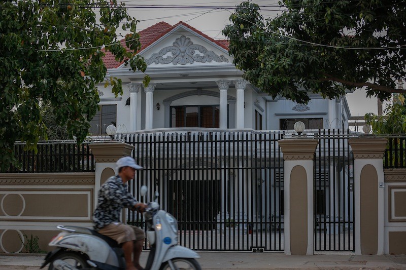 A man drives by a villa in Phnom Penh where 13 teenagers were found by police, who initially suspected they were human trafficking victims. (Siv Channa/The Cambodia Daily)