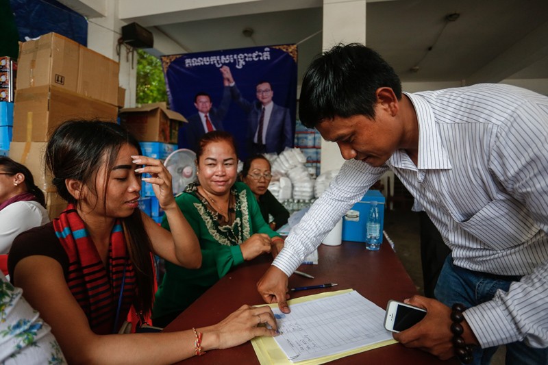 Opposition supporters thumbprint a petition to King Norodom Sihamoni at the CNRP's headquarters in Phnom Penh yesterday. (Siv Channa/The Cambodia Daily)