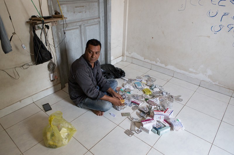 Soewin Sabirahmad at his home in Kompong Chhnang province in March, surrounded by various painkillers—which he says he has since stopped taking. (Hannah Hawkins/The Cambodia Daily)
