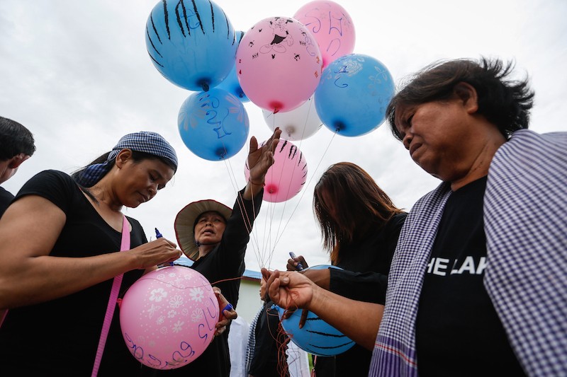 Activists write slogans on balloons in Phnom Penh's Pur Senchey district during the eighth 'Black Monday' protest on Monday. (Siv Channa/The Cambodia Daily)