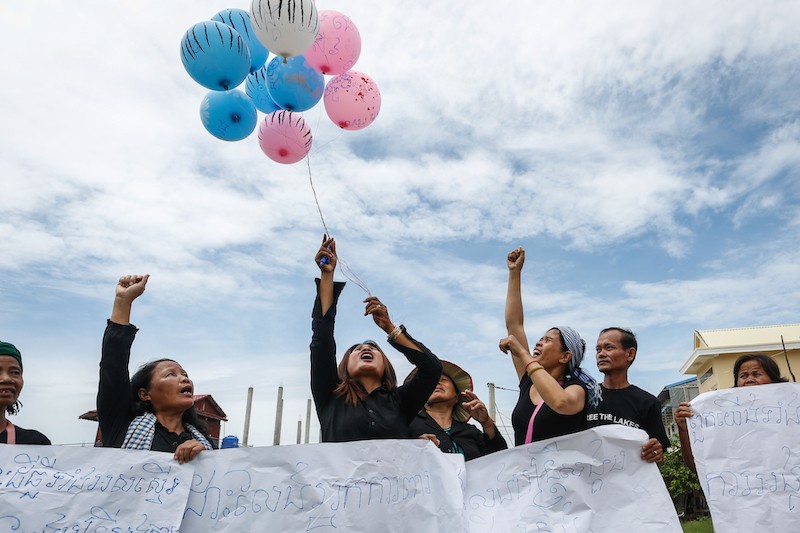 Activists hold up posters and balloons in Phnom Penh’s Pur Senchey district during the eighth ‘Black Monday’ protest yesterday. (Siv Channa/The Cambodia Daily)