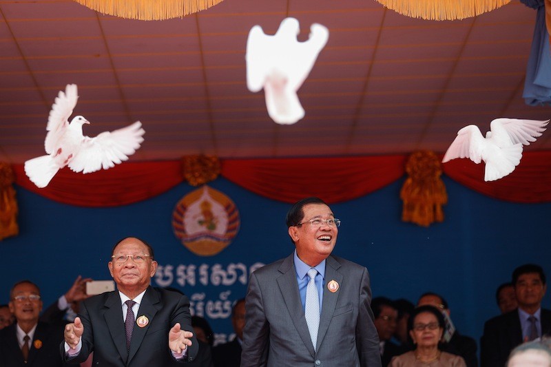 National Assembly President Heng Samrin, left, and Prime Minister Hun Sen release doves during a ceremony marking the CPP's 65th anniversary at the party's headquarters in Phnom Penh on Tuesday. (Siv Channa/The Cambodia Daily)