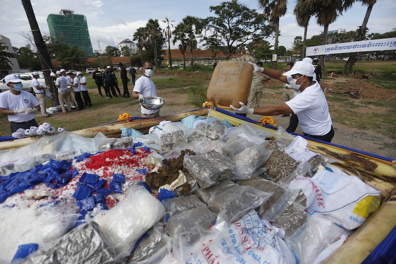 An official pours gasoline onto a pyre of 1.5 tons of confiscated drugs yesterday at a ceremony in Phnom Penh to mark World Drug Day. (Siv Channa/The Cambodia Daily)