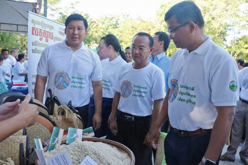 Environment Minister Say Sam Al, left, and Education Minister Hang Chuon Naron, right, look at goods on display during an event to mark World Environment Day in Phnom Penh yesterday, in a photograph posted to Mr. Chuon Naron’s Facebook page. 
