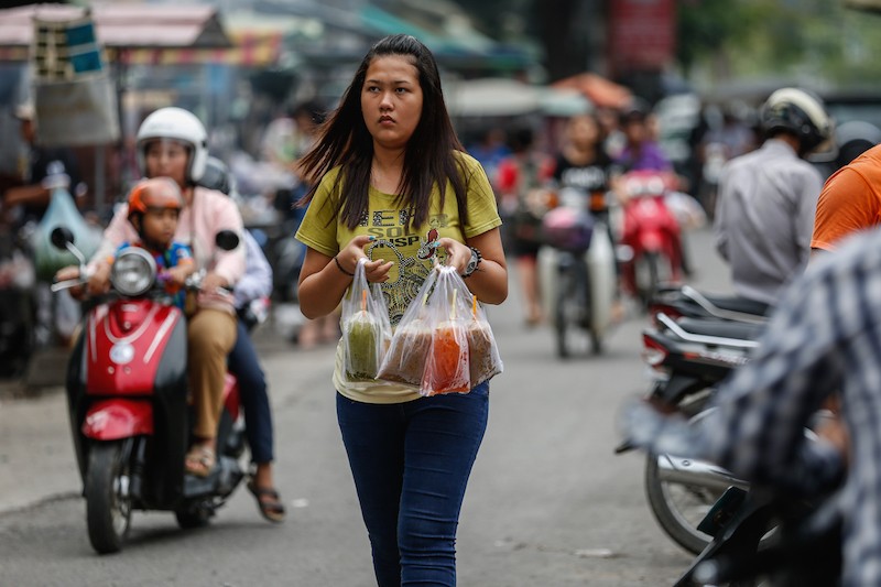 A woman carries beverages in plastic bags near Phsar Kap Kor market in Phnom Penh yesterday afternoon. (Siv Channa/The Cambodia Daily)
