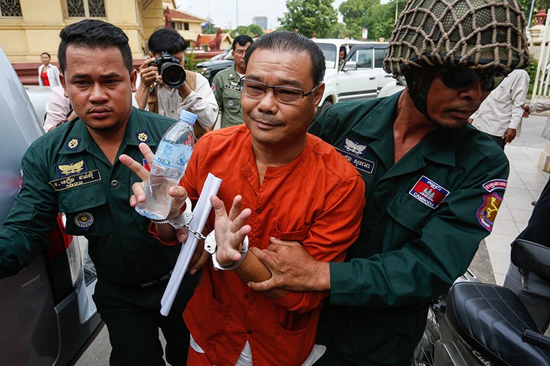 Opposition Senator Hong Sok Hour is escorted into the Supreme Court in Phnom Penh in June. (Siv Channa/The Cambodia Daily)