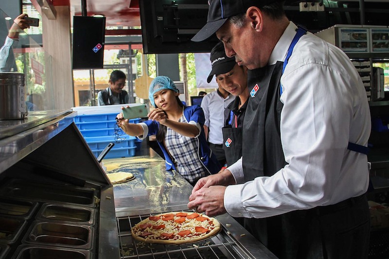 U.S. Ambassador William Heidt prepares a pizza at a Domino’s Pizza outlet in Phnom Penh on Monday, in a photograph posted to the company’s local Facebook page.