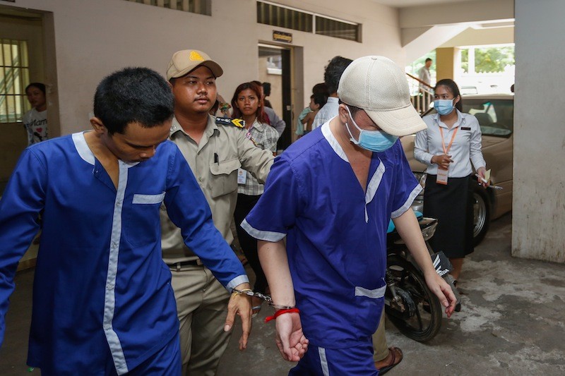 Interior Ministry official Keo Sovannarith, right, leaves the Phnom Penh Municipal Court on Tuesday after being found guilty of murder. (Siv Channa/The Cambodia Daily)