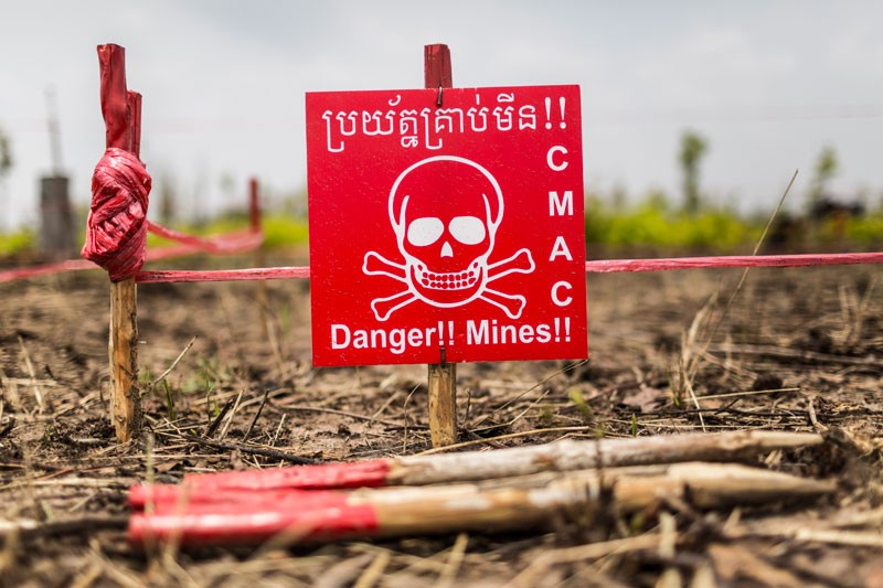 A danger sign marks a minefield be- ing cleared by CMAC in Battambang’s Bavel district. (Enric Catala)