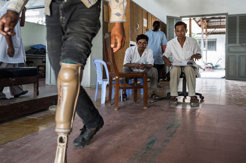 Staff watch a patient test out his new leg. (Enric Catala)