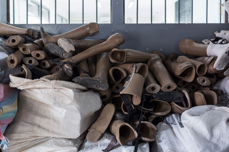 Discarded prosthetic legs are piled up before being shipped to Phnom Penh to be recycled. (Enric Catala)