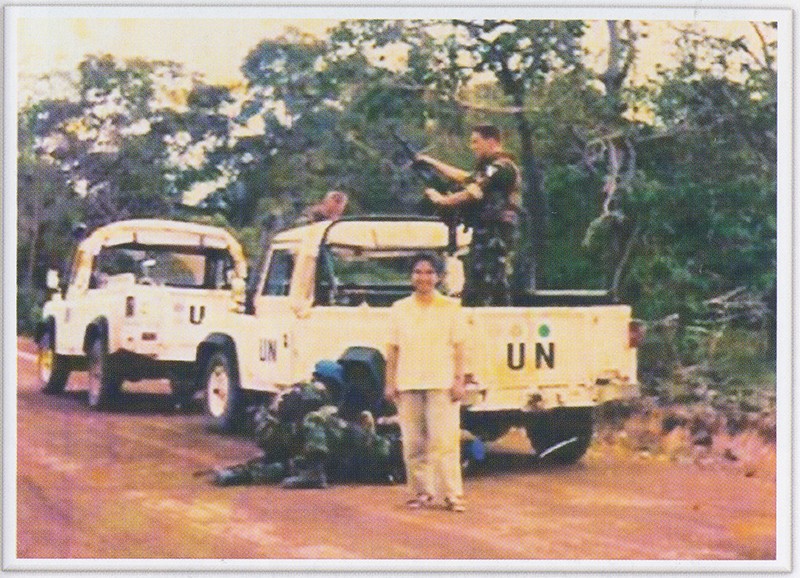 Ms. Vannath poses for a photograph while UN soldiers replace a flat tire in the Khmer Rouge zone of northwestern Cambodia in April 1993. (Chea Vannath collection)