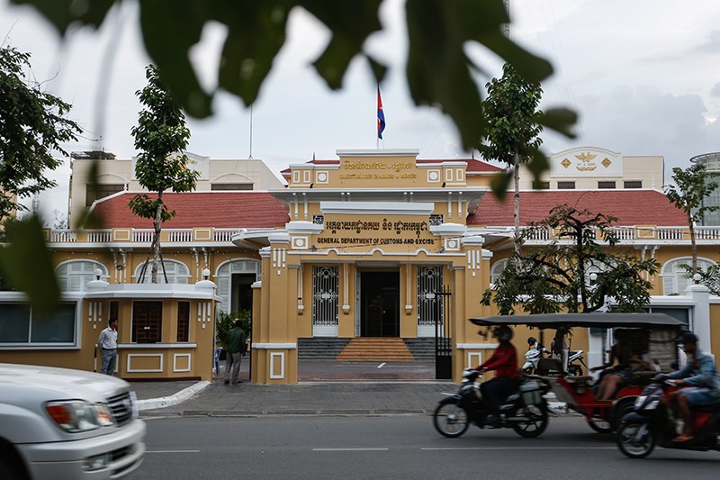 Motorists drive past the Phnom Penh headquarters of the Finance Ministry's customs and excise department on Friday. (Siv Channa/The Cambodia Daily)
