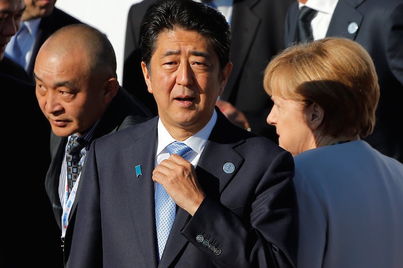 Japanese Prime Minister Shinzo Abe adjusts his necktie during the Asia-Europe Meeting in Ulaanbaatar, Mongolia, on Saturday. (Reuters)