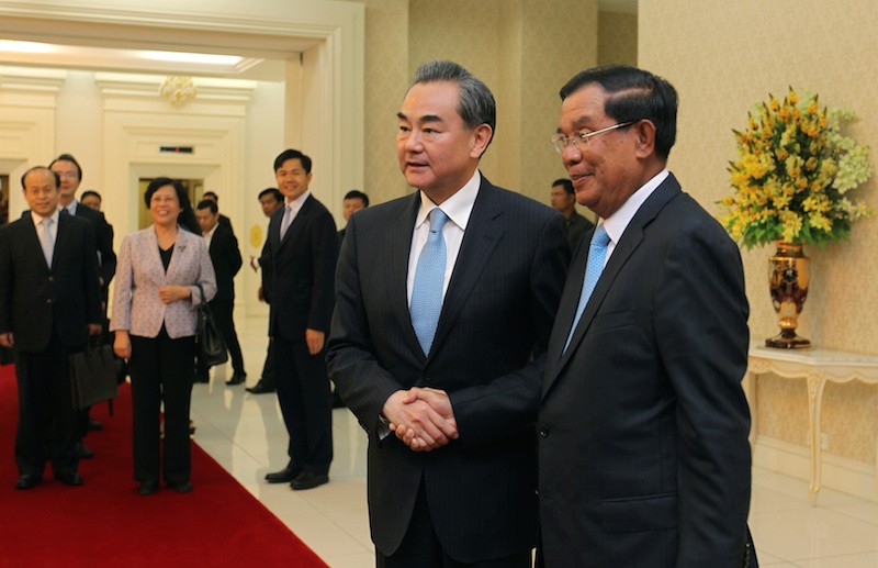 Prime Minister Hun Sen, right, shakes hands with Chinese Foreign Minister Wang Yi in Phnom Penh in April. (Pring Samrang/Reuters)